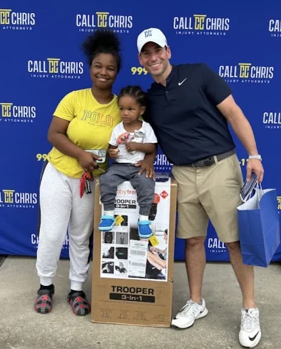 A mother and child receiving a free car seat at the Corzo Cares car seat giveaway