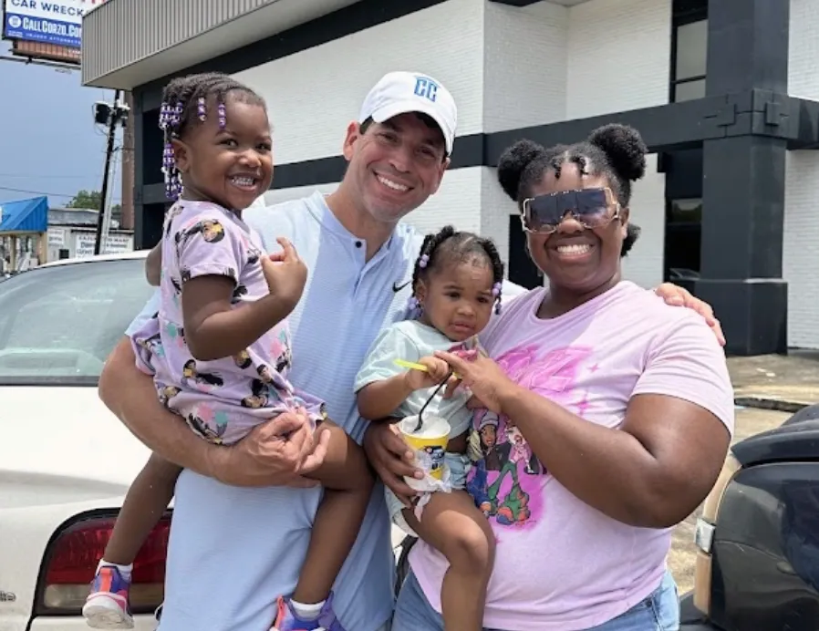 Chris Corzo with a family and their two daughters at a Corzo Cares giveaway