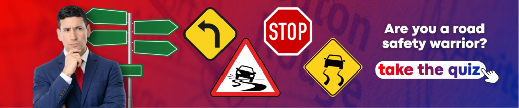 Promotional banner featuring a man in a suit with a thoughtful expression on the left, surrounded by various road signs including stop, curve, and slippery road warnings. Text reads “Are you a road safety warrior?” with a call to action button that says “Take the quiz.” The background uses red and purple tones.